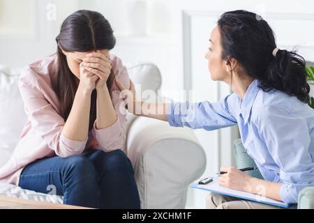 Crying Woman Talking to Therapist on Couch Stock Photo