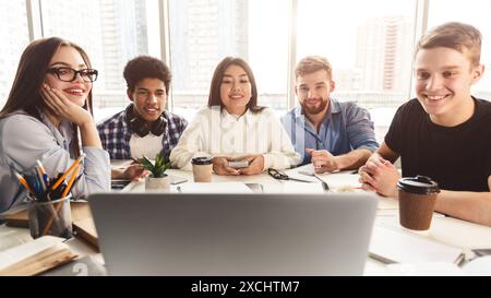 Online lesson. Students learning by laptop in library Stock Photo