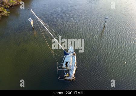 Aerial view of sunken sailboat on shallow bay waters after hurricane in Manasota, Florida Stock Photo