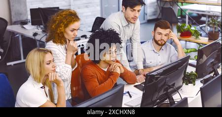 Diverse Team of Professionals Working on Computers in Modern Office Stock Photo