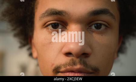 Extreme close up portrait African American ethnic guy male man looking down close eyes close gaze look at camera face healthy skincare medicine facial Stock Photo