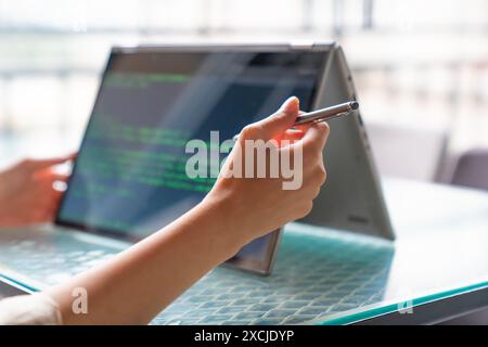 Female freelance developer coding and programming. Coding on two with screens with code language and application. Stock Photo