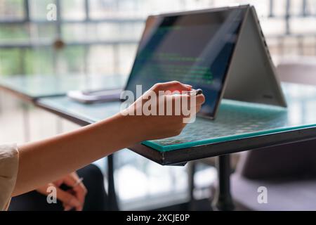 Female freelance developer coding and programming. Coding on two with screens with code language and application. Stock Photo