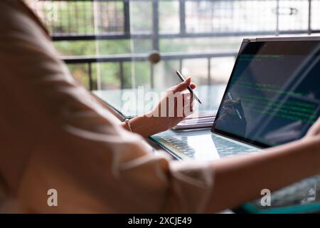 Female freelance developer coding and programming. Coding on two with screens with code language and application. Stock Photo