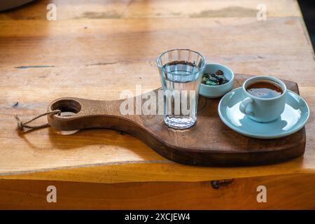 Turkish coffee presentation with pebble chocolate and a glass of water, showcasing a traditional, elegant setup on the table. Stock Photo