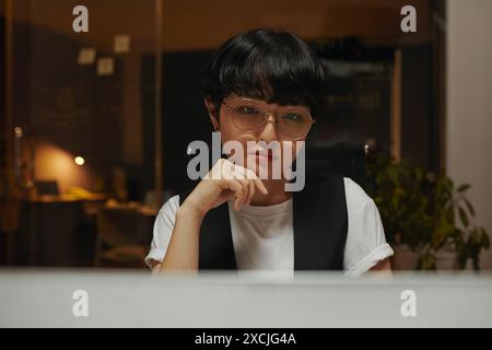 Pensive programmer looking at code on computer screen solving problem Stock Photo