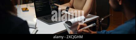 Header with developer showing code on laptop screen in meeting Stock Photo