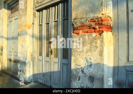 The door of an old building with faded walls down to the brickwork. Stock Photo