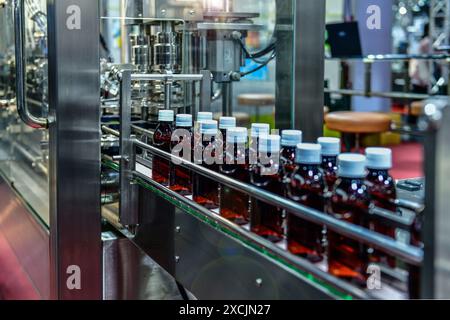 Glass bottles in a conveyor belt on a high quality automatic in the factory production line Stock Photo