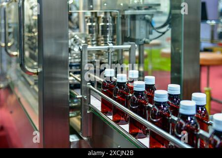 Glass bottles in a conveyor belt on a high quality automatic in the factory production line Stock Photo