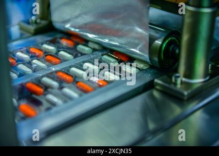 Capsule medicine pills during production line and packing process on modern pharmaceutical factory, Medical Drug Manufacturing. Stock Photo