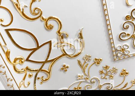 Classic luxury interior fragment with white ceiling and wall decorated with golden details Stock Photo