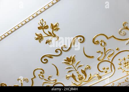 White ceiling decoration with golden bas relief gypsum details. Classic luxury interior Stock Photo