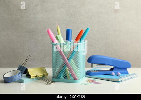 Stapler, holder and other different stationery on white table Stock Photo