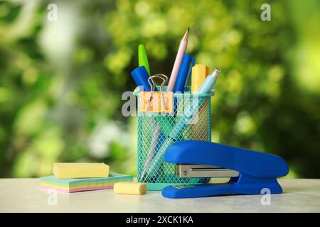 Stapler, holder and other different stationery on white table Stock Photo