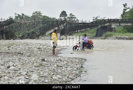 Guwahati, Guwahati, India. 16th June, 2024. A two wheeler cross through Diring river after RCC Bridge which has been washed away in flood water in Baksa district of Assam India on Sunday 16th June 2024 (Credit Image: © Dasarath Deka/ZUMA Press Wire) EDITORIAL USAGE ONLY! Not for Commercial USAGE! Stock Photo