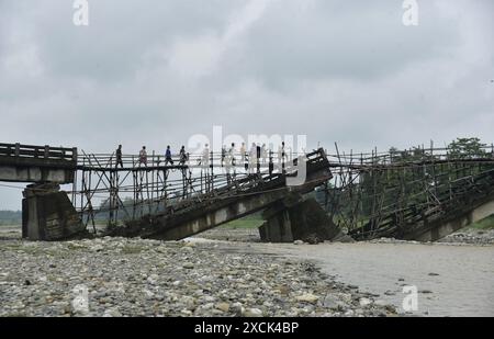 Guwahati, Guwahati, India. 16th June, 2024. Villagers cross a temporary bamboo bridge constructed over Diring river to link a RCC Bridge which has been washed away in flood water in Baksa district of Assam India on Sunday 16th June 2024. (Credit Image: © Dasarath Deka/ZUMA Press Wire) EDITORIAL USAGE ONLY! Not for Commercial USAGE! Stock Photo