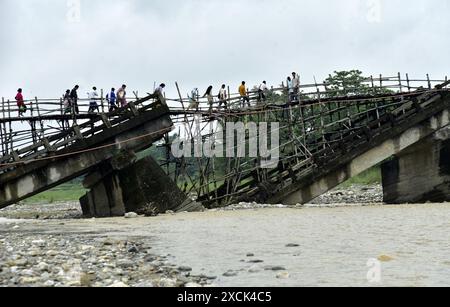 Guwahati, Guwahati, India. 16th June, 2024. Villagers cross a temporary bamboo bridge constructed over Diring river to link a RCC Bridge which has been washed away in flood water in Baksa district of Assam India on Sunday 16th June 2024. (Credit Image: © Dasarath Deka/ZUMA Press Wire) EDITORIAL USAGE ONLY! Not for Commercial USAGE! Stock Photo
