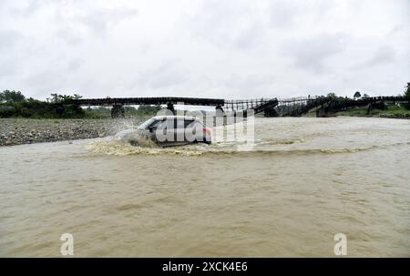 Guwahati, Guwahati, India. 16th June, 2024. A vehicle wades through Diring river after RCC Bridge which has been washed away in flood water in Baksa district of Assam India on Sunday 16th June 2024. (Credit Image: © Dasarath Deka/ZUMA Press Wire) EDITORIAL USAGE ONLY! Not for Commercial USAGE! Stock Photo