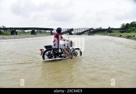 Guwahati, Guwahati, India. 16th June, 2024. A two wheeler cross through Diring river after RCC Bridge which has been washed away in flood water in Baksa district of Assam India on Sunday 16th June 2024 (Credit Image: © Dasarath Deka/ZUMA Press Wire) EDITORIAL USAGE ONLY! Not for Commercial USAGE! Stock Photo
