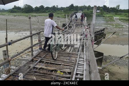 Guwahati, Guwahati, India. 16th June, 2024. Villagers cross a temporary bamboo bridge constructed over Diring river to link a RCC Bridge which has been washed away in flood water in Baksa district of Assam India on Sunday 16th June 2024. (Credit Image: © Dasarath Deka/ZUMA Press Wire) EDITORIAL USAGE ONLY! Not for Commercial USAGE! Stock Photo
