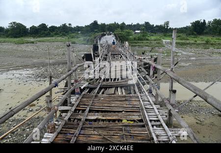 Guwahati, Guwahati, India. 16th June, 2024. A child trying to cross a temporary bamboo bridge constructed over Diring river to link a RCC Bridge which has been washed away in flood water in Baksa district of Assam India on Sunday 16th June 2024. (Credit Image: © Dasarath Deka/ZUMA Press Wire) EDITORIAL USAGE ONLY! Not for Commercial USAGE! Stock Photo