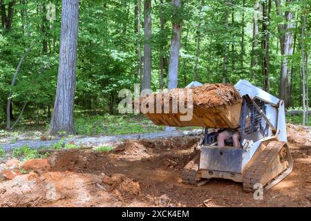 Tractor is being used to level ground at an earthmoving job in backyard Stock Photo