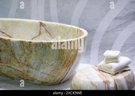 Freestanding onyx bathtub in natural stone finish bathroom. Selective focus. Stock Photo