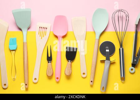 Different spatulas and other kitchen utensils on color background, flat lay Stock Photo