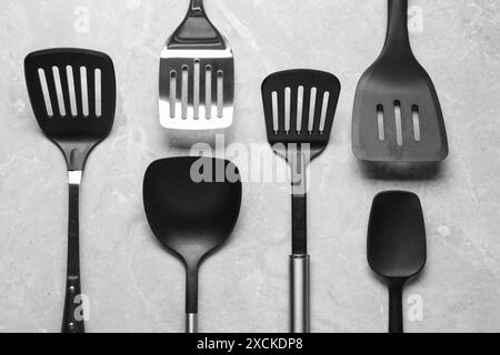 Different spatulas on grey marble table, flat lay Stock Photo