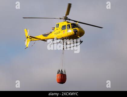 Firefighting with fire brigade helicopter using extinguishing water in Gran Canaria Stock Photo