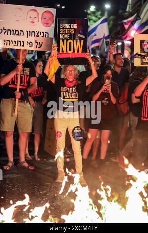 Jerusalem, Israel. 17th June 2024 Participants of an antigovernment demonstration near Israel's Prime Minister (Netanyahu) private house in Jerusalem. The demonstrators were calling for a new election and the release of the hostages through a deal between Israel and Hamas. The protestors are rasing signs. In front of them is a bonfire. Credit: Yoram Biberman/Alamy Live News. Stock Photo