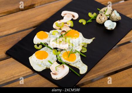 Fried quail eggs with champignons Stock Photo