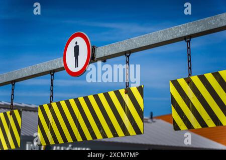 Red And Yellow Road Signs Hanging From Chains On A Bar Stock Photo