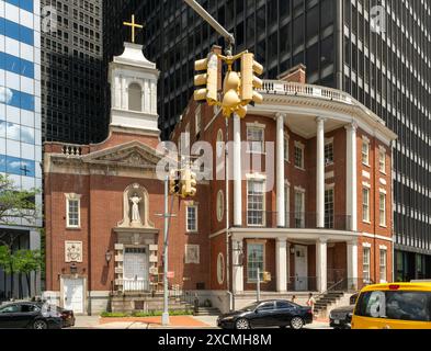 New York, NY – US – June 7, 2024 Tourists stroll by the Colonial Revival styled Shrine of St. Elizabeth Ann Bayley in lower Manhattan, its red and whi Stock Photo