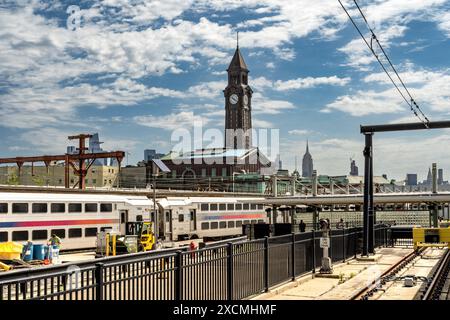 Hoboken, NJ - US - June 7, 2024 Landscape view of the train-yard near Hoboken Terminal offers a bustling scene against the backdrop of the iconic NYC Stock Photo