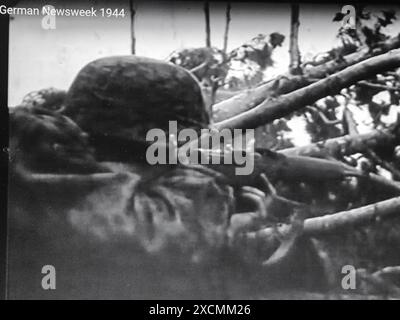 World War Two B&W Screenshot photo . A Waffen SS Soldier in Camo Smock fires his G43 Semi Automatic Rifle in 1944 Stock Photo