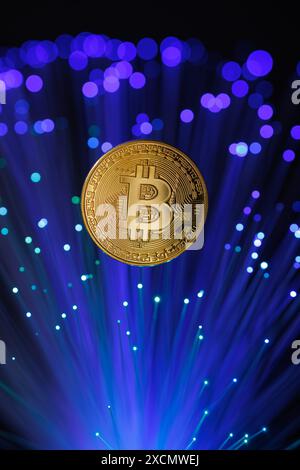 Glowing Bitcoin cryptocurrency against the background of fiber optic cables. Bitcoin digital cryptocurrency consisting of dots and lines, cryptocurren Stock Photo