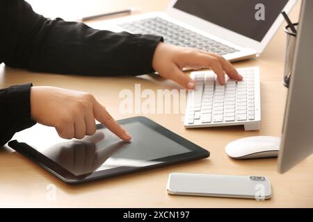 Female programmer working with tablet computer in office, closeup Stock Photo