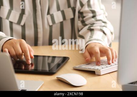 Female programmer working with tablet computer in office, closeup Stock Photo