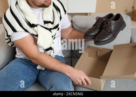 Man with pair of stylish leather shoes on sofa at home Stock Photo