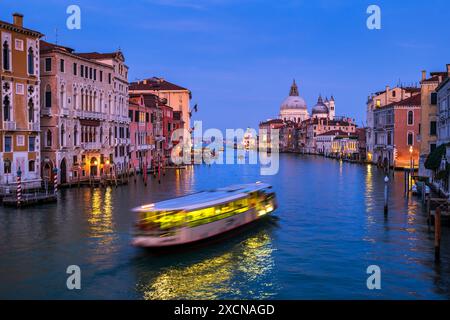 City of Venice in the evening, Italy. The Grand Canal towards the end with water bus between San Marco and Dorsoduro districts, view from Accademia Br Stock Photo