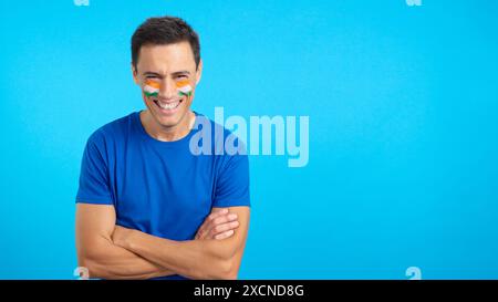 Man standing with indian flag painted on face smiling Stock Photo
