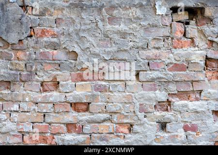 Destroyed plaster on an old red brick wall. Grunge background Stock Photo