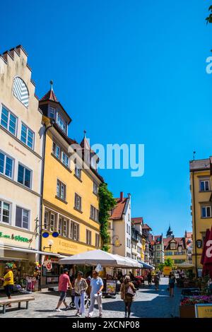 Lindau, Germany, June 14, 2023, Beautiful colorful facades of historical buildings in the city with many tourists passing by in summer with blue sky Stock Photo