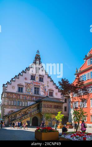 Lindau, Germany, June 14, 2023, Beautiful colorful facade of old historical townhall building of the city with many tourists passing by in summer with Stock Photo