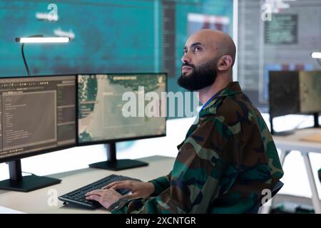 Reconnaissance specialist using the military CCTV surveillance system to detect any dangerous warships or vessels. IT engineer working in federal control center power base with a big screen. Stock Photo