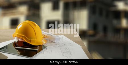 Yellow hardhat, essential safety equipment for construction workers and architects, lies beside blueprints showcasing the building plans Stock Photo