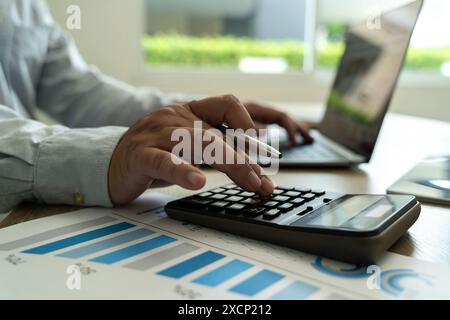 Close-up businessman using calculate finances of hands typing on a laptop keyboard in an office setting  report in office Stock Photo