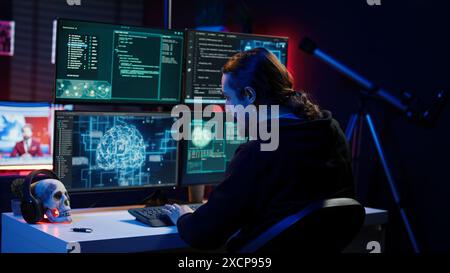 Hacker drinking coffee while running artificial intelligence spyware software designed to gather information from users. Script kiddie doing illegal stuff using AI, consuming beverage, camera B Stock Photo